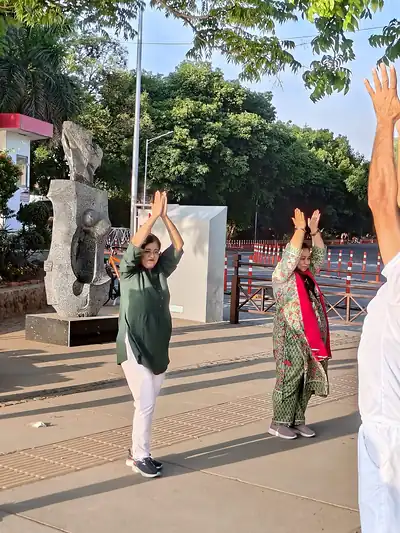 Participants doing group exercise near sculpture, Millet Cyclothon