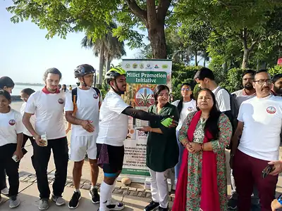 Cyclists and organisers with Millet Promotion Initiative standee