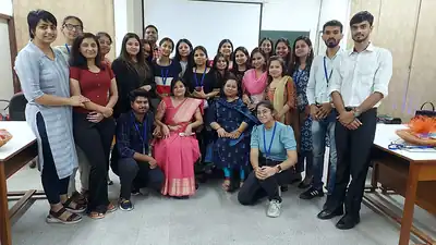 Large group of workshop participants and faculty seated and standing together