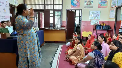 Facilitator speaking to community women at nutrition awareness session
