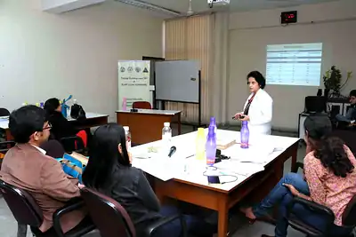 Woman faculty in white coat presenting to seated participants at 2nd NWHSS 2016, PGIMER Chandigarh