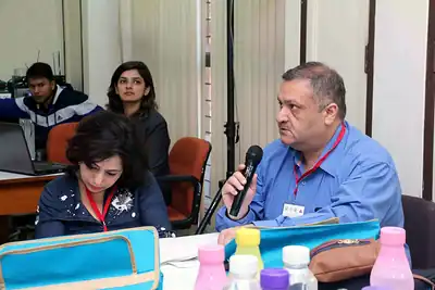Participant with microphone speaking at workshop table at 2nd NWHSS 2016, PGIMER Chandigarh