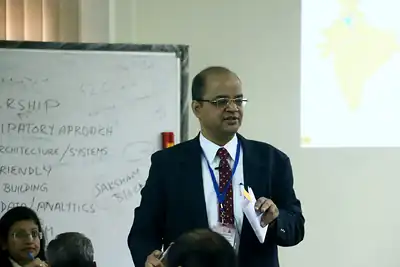 Speaker presenting a framework on a whiteboard and screen, 4th NWHSS, PGIMER Dec 2018