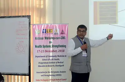Speaker presenting with a microphone beside a screen, 4th NWHSS, PGIMER Dec 2018