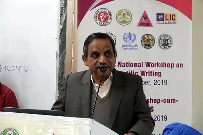 Speaker at the podium in front of the workshop banner, 6th NWHSS with Scientific Writing workshop, PGIMER Dec 2019