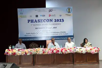 Dais with flower-decked table and conference banner at PHASECON 2023