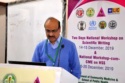 Presenter at laptop with workshop banner, scientific writing workshop 2019