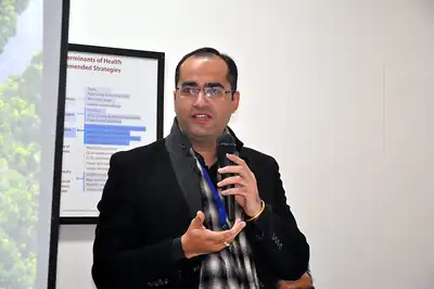 Speaker with microphone in front of presentation slide