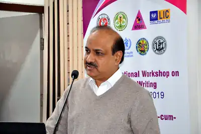 Speaker at microphone in front of workshop banner